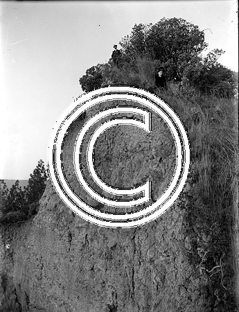 Man & woman atop steep cliff