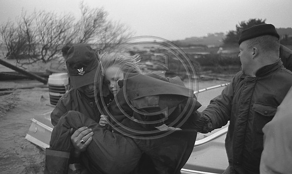 Coast Guardsman carrying little girl